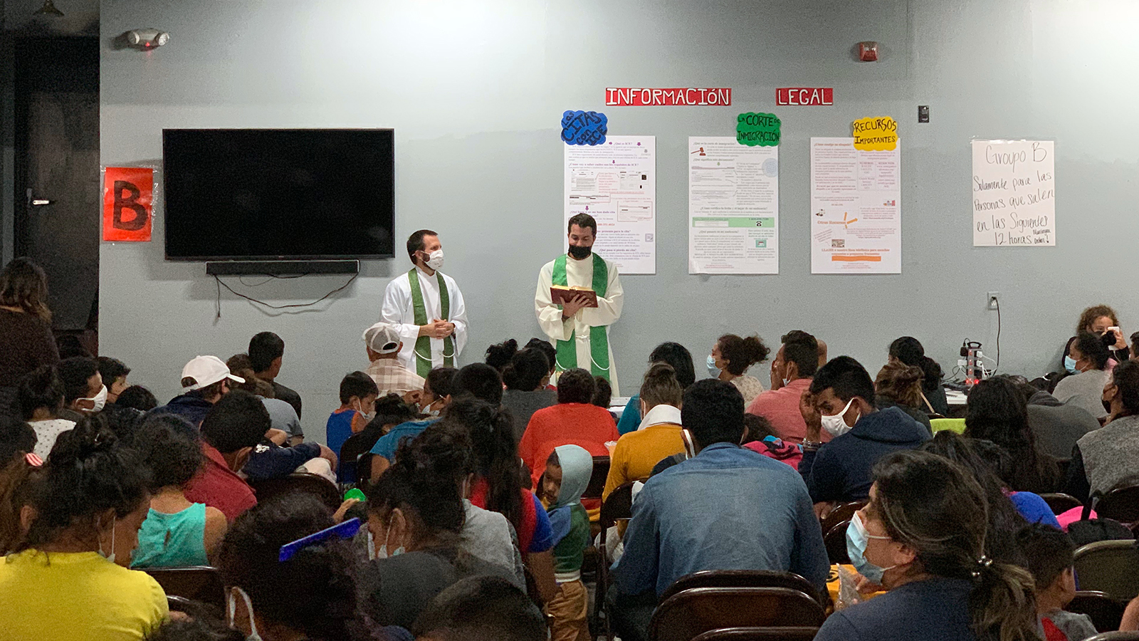 Reverend Brian A. Strassburger, left, and Reverend Louie Hotop speak to migrants at a humanitarian respite center in McAllen, Texas.  Courtesy photo