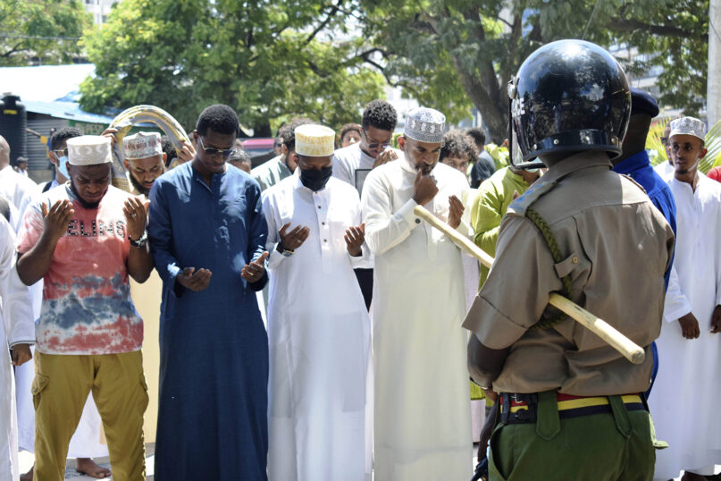 A Kenyan police officer stands guard as Muslim worshippers pray in Mombasa, Kenya, on Nov. 12, 2021. (AP Photo/Gideon Maundu)