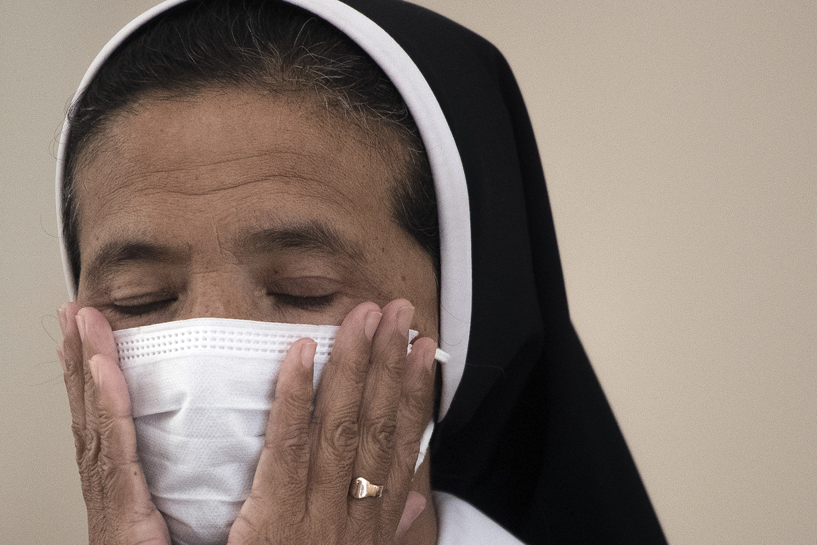 Colombian nun Gloria Cecilia Narvaez, who was held captive for nearly five years by the Mali-based Islamic insurgency, places her hands on her face during a press conference in Bogota, Colombia, Friday, Nov. 19, 2021. The nun, who was seized near the border with Burkina Faso and held since Feb. 7, 2017, was released on Oct. 9, 2021. (AP Photo/Ivan Valencia)