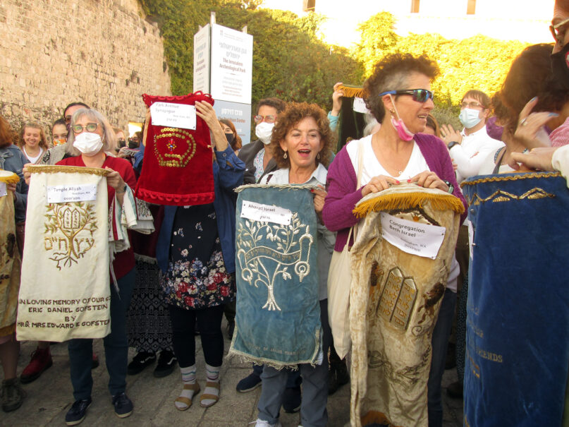 On their way to the Western Wall, the Women of the Wall prayer group holds Torah mantels, or covers, from synagogues around the world, Friday, Nov. 5, 2021, in Jerusalem's Old City. The synagogues sent the covers in solidarity with Women of the Wall, which has been denied permission to bring Torah scrolls to the Western Wall. RNS photo by Michele Chabin