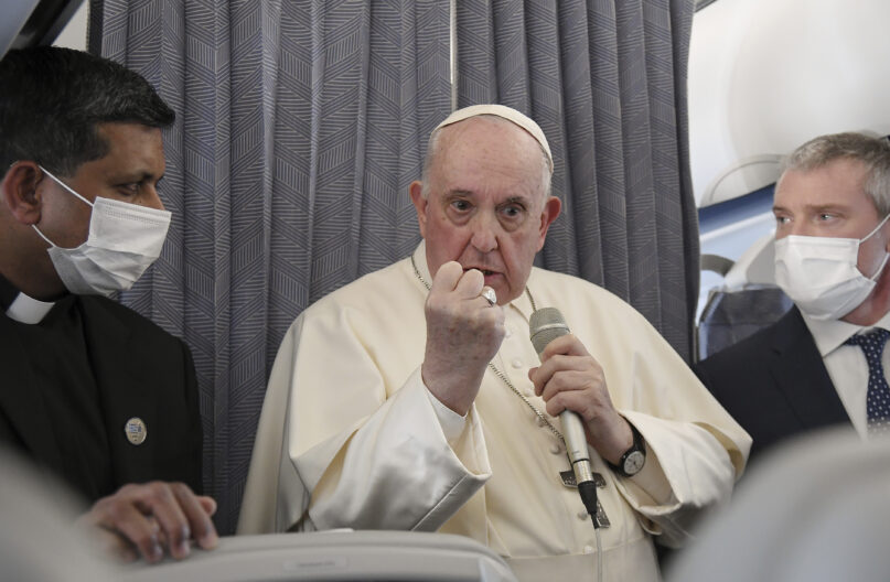 Pope Francis greets the journalists onboard the papal plane on the occasion of his five-day pastoral visit to Cyprus and Greece, Monday, Dec. 6, 2021. Francis' five-day trip to Cyprus and Greece has been dominated by the migrant issue and Francis' call for European countries to stop building walls, stoking fears and shutting out 