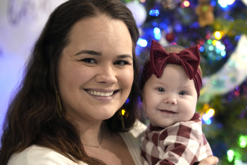 Kelsey Wright holds her 4-month-old daughter, Berklee, on Saturday, Dec. 18, 2021, in Montgomery, Texas. Year after year, several thousand women in the U.S. choose to carry an unintended pregnancy to term and then place the baby for adoption, relinquishing their parental rights. Wright chose adoption — twice — before having Berklee. (AP Photo/David J. Phillip)
