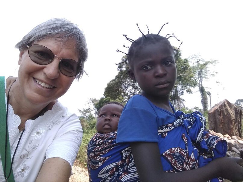 In this Feb. 12, 2021, photo provided by Sister Luzia Premoli, she takes a selfie with a young girl in the village of Bagandou in the Central African Republic. In 2014 Pope Francis appointed Premoli to a Vatican congregation and she became the first women in the history of the Catholic Church to take on this role. Premoli is currently teaching young women about the Bible and Christianity and works with a community of Pygmies on education and agricultural initiatives in the equatorial forest in the Central African Republic. (Sister Luzia Premoli via AP)