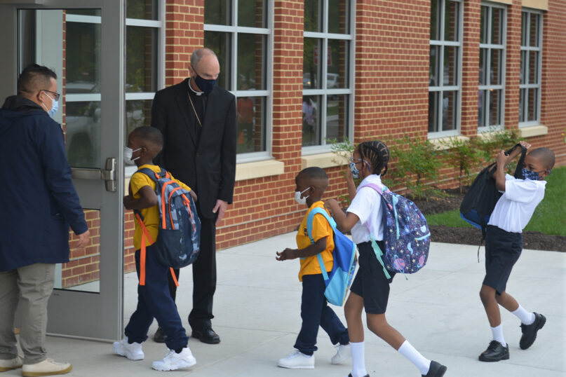 Youngsters enter the first new Catholic school built in Baltimore in roughly 60 years with a mix of enthusiasm and first-day jitters, Aug. 30, 2021. The 65,000-square-foot school near downtown Baltimore is an anomaly in the national education landscape, where the pandemic has shuttered many parish schools. It’s named after Mother Mary Lange, who started a Catholic school for Black children in 1828. (AP Photo/David McFadden)