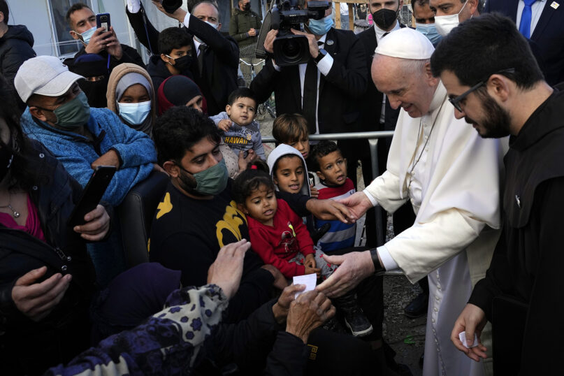 Pope Francis meets migrants during his visit at the Karatepe refugee camp, on the northeastern Aegean island of Lesbos, Greece, Sunday, Dec. 5, 2021. (AP Photo/Alessandra Tarantino)