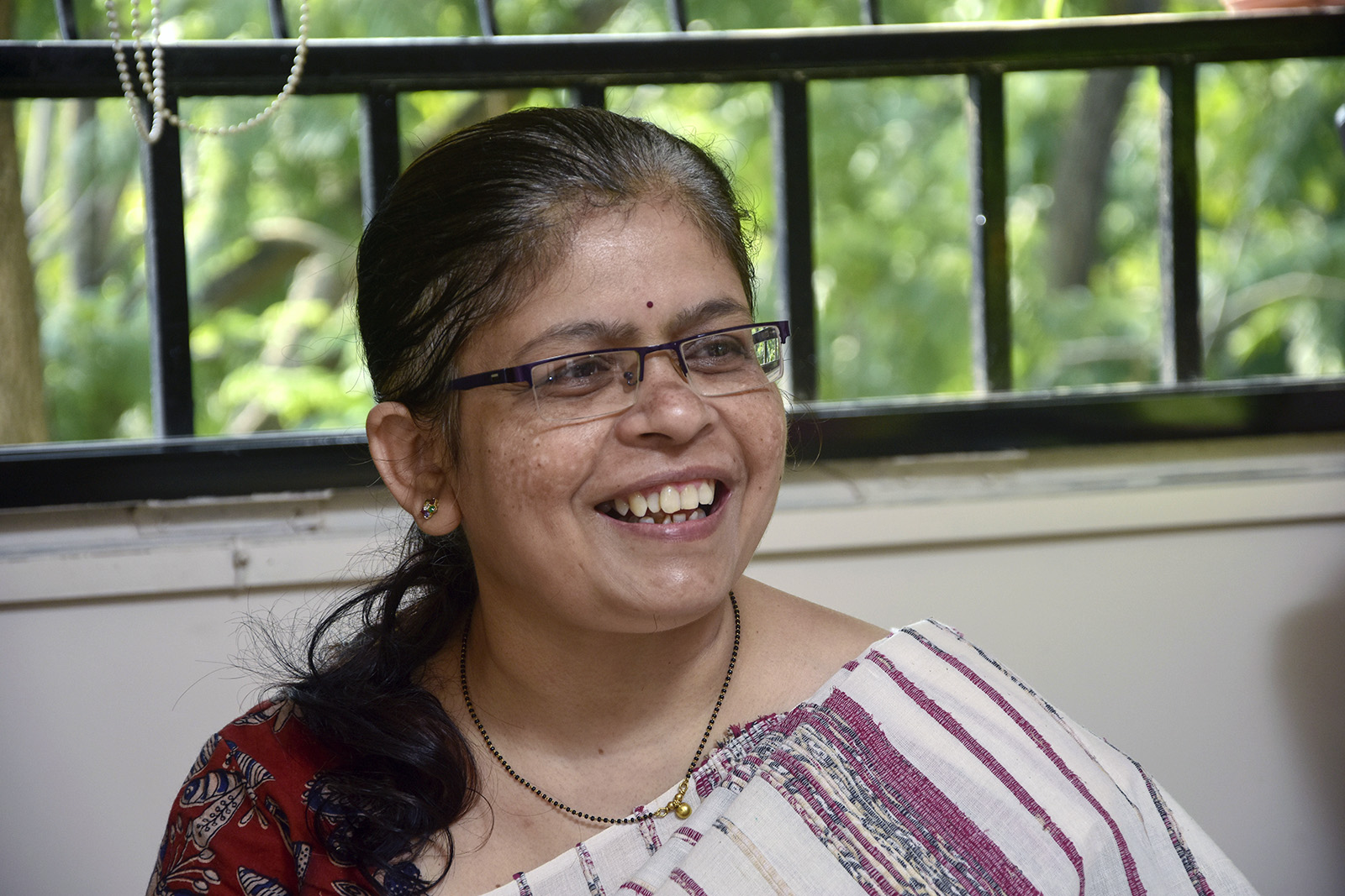 Manisha Shete, a practicing Hindu priest, smiles as she performs posthumous rituals for her client's mother at a residence in Pune, India, Wednesday, Oct. 20, 2021. Shete, who first began to officiate at religious ceremonies in 2008, said demand is growing and “people have started accepting women priests.” (AP Photo/Abhijit Bhatlekar)