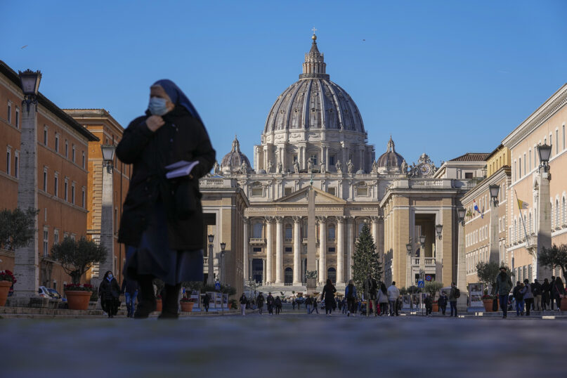 A masked nun walks away from St. Peter's Square and Basilica, at the Vatican, Dec. 17, 2021. (AP Photo/Andrew Medichini)