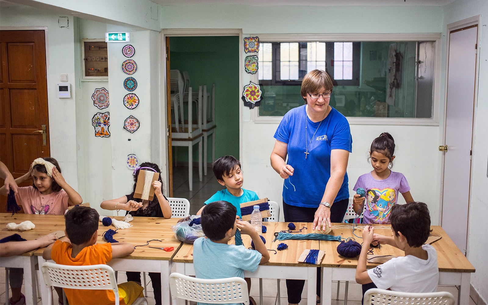 Sister Ewa Pliszczak leads activities with children at the Jesuit Refugee Service's office in Athens, Greece. Photo by Kristof Holvenyi