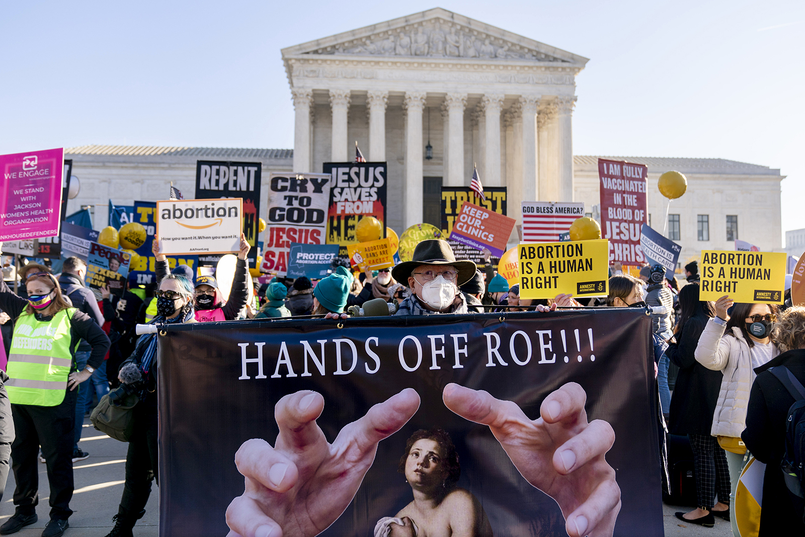 Stephen Parlato of Boulder, Colorado, holds a sign that reads "Hands Off Roe!!!" as abortion rights advocates and abortion opponents demonstrate in front of the U.S. Supreme Court, Dec. 1, 2021, in Washington. The court was hearing arguments in a case from Mississippi, where a 2018 law would ban abortions after 15 weeks of pregnancy, well before viability. (AP Photo/Andrew Harnik)