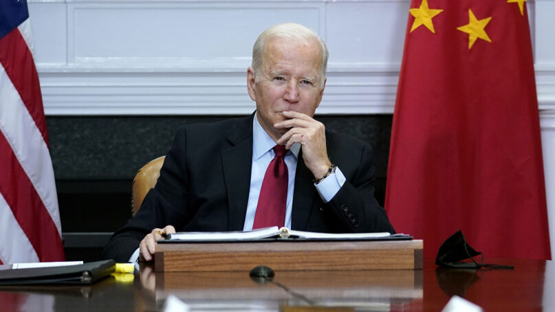 FILE - President Joe Biden listens as he meets virtually with Chinese President Xi Jinping from the Roosevelt Room of the White House in Washington, Nov. 15, 2021. The Biden administration announced on Thursday that it is levying new sanctions against several Chinese biotech and surveillance companies operating out of Xinjiang province, casting another shot at Beijing over human rights abuses against Uyghurs in western China. (AP Photo/Susan Walsh, File)
