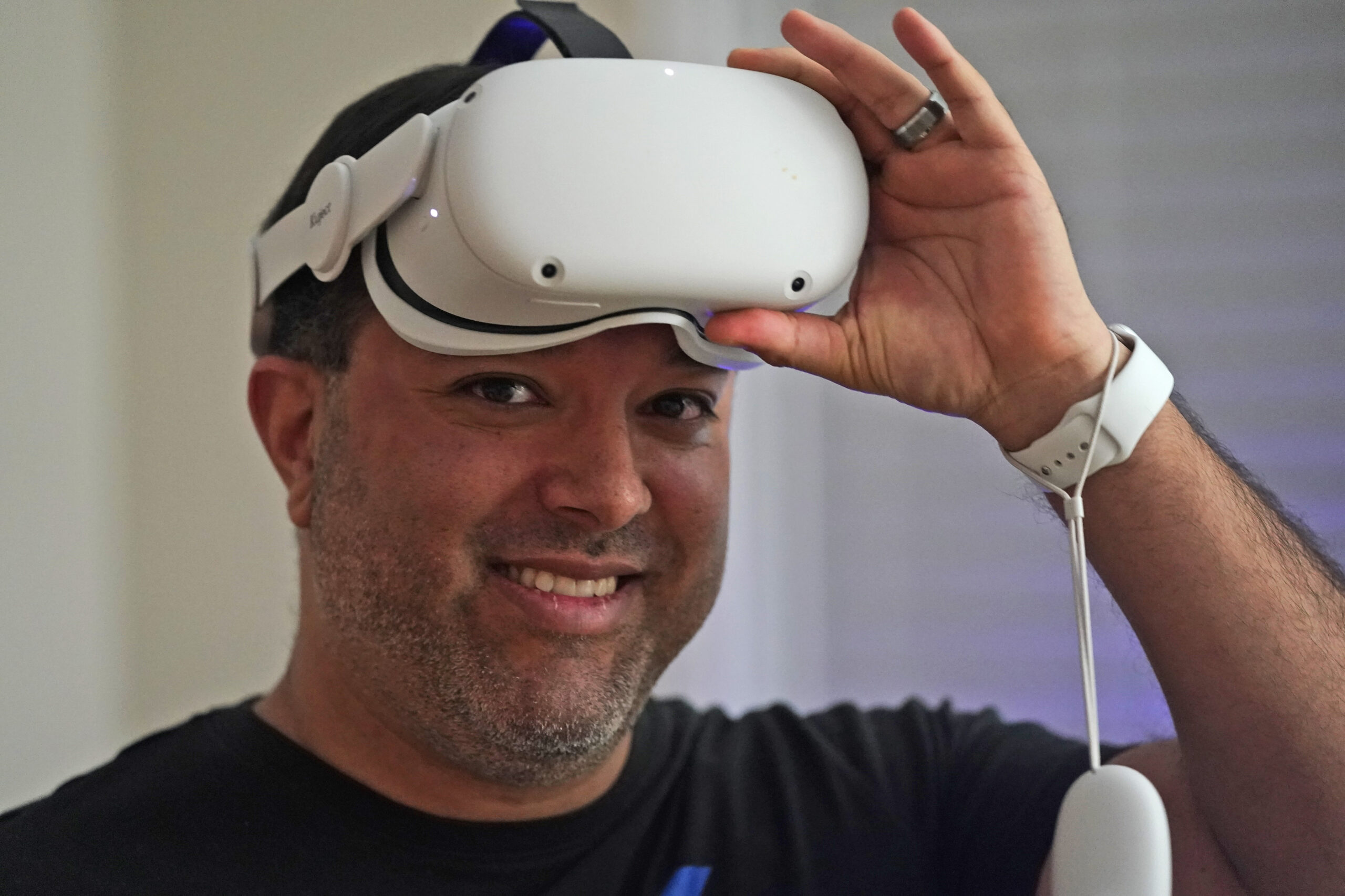 Pastor D.J. Soto, the lead pastor of VR Church, removes his VR goggles after a sermon in his home Sunday Jan. 23, 2022, in Fredericksburg, Va. Soto sings, preaches and performs digital baptisms in the metaverse to a growing congregation of avatars. (AP Photo/Steve Helber)