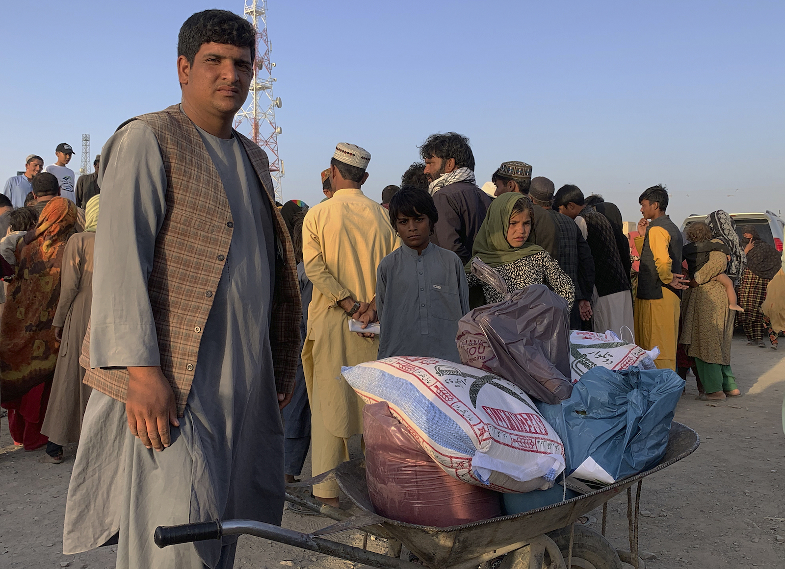 An Afghan man prepares to push a wheelbarrow with foodstuff distributed by an Islamabad-based Christian organization on the outskirts of Chaman, a border town in Pakistan’s southwestern Baluchistan province, Aug. 31, 2021. Dozens of Afghan families crossed into Pakistan through the southwestern Chaman border a day after the U.S. wrapped up its 20-year military presence in the Taliban-controlled country. (AP Photo)