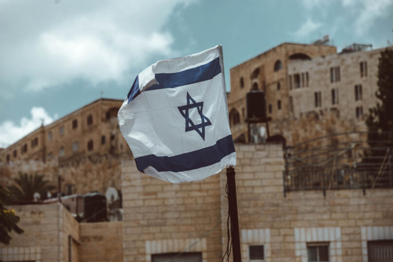 The Israeli flag flies in Jerusalem. Photo by Taylor Brandon/Unsplash/Creative Commons