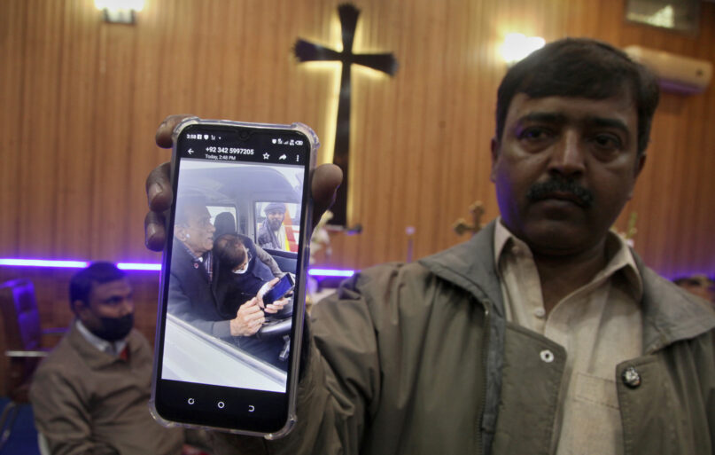 A man shows a picture to journalists of Christian priest Father William Siraj, shortly after he was killed by unknown gunmen, at a church in the northwestern city of Peshawar Pakistan, Sunday, Jan. 30, 2022. Police said gunmen killed Siraj  and wounded another priest as they were driving home from Sunday Mass. (AP Photo/Muhammad Sajjad)