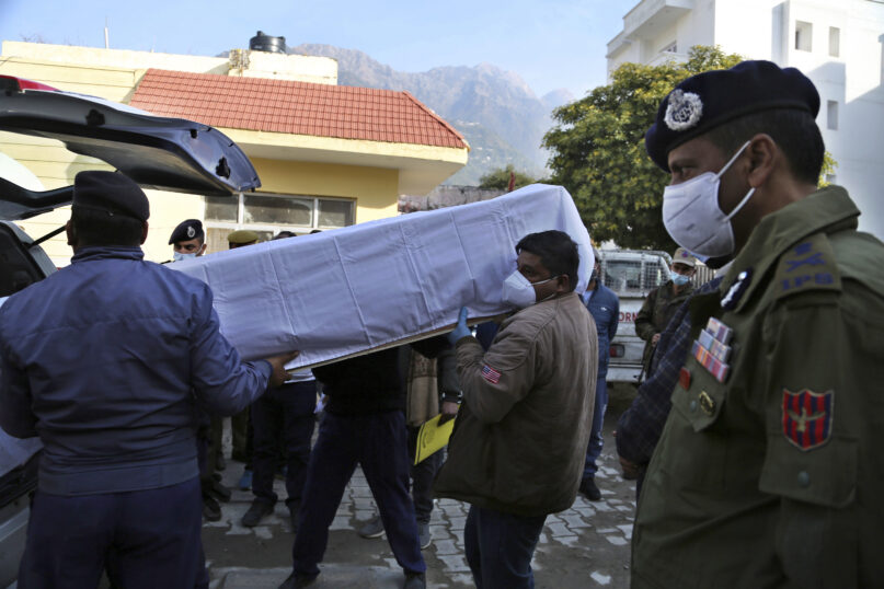 Health workers carry the coffin of a victim, who died in a stampede at the Mata Vaishnav Devi shrine, at a hospital in Katra, India, Saturday, Jan. 1, 2022. A stampede at a popular Hindu shrine in Indian-controlled Kashmir killed at least 12 people and injured 13 others on New Year’s Day, officials said. (AP Photo/Channi Anand)