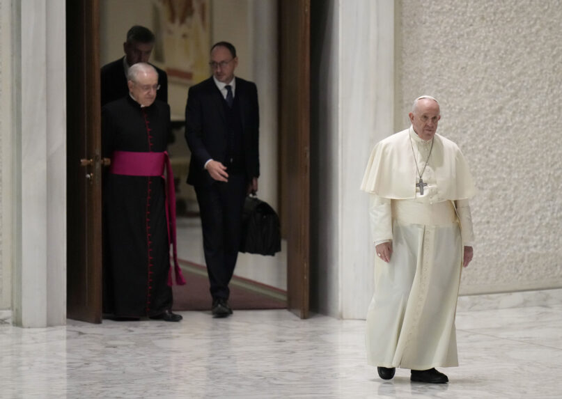 Pope Francis walks to reach his chair as he arrives for his weekly general audience in the Paul VI Hall, at the Vatican, Wednesday, Jan. 26, 2022. (AP Photo/Alessandra Tarantino)