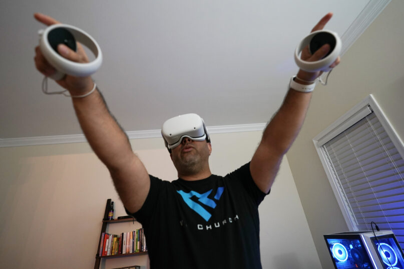 Pastor D.J. Soto, the lead pastor of VR Church, delivers a sermon in his home Sunday Jan. 23, 2022, in Fredericksburg, Va. Soto sings, preaches and performs digital baptisms in the metaverse to a growing congregation of avatars. (AP Photo/Steve Helber)