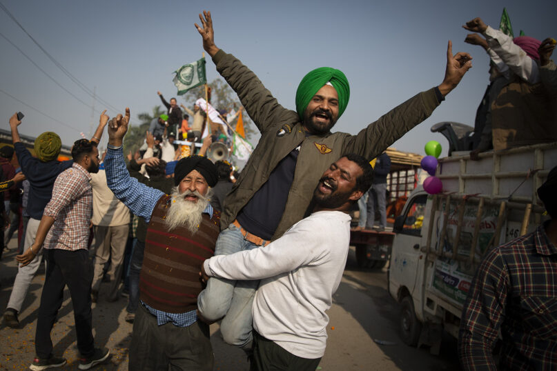 Indian farmers celebrate while leaving the protest site in Singhu, on the outskirts of New Delhi, Dec. 11, 2021. Tens of thousands of jubilant Indian farmers cleared protest sites on the capital’s outskirts and began returning home, marking an end to their yearlong demonstrations against agricultural reforms that were repealed by Prime Minister Narendra Modi’s government in a rare retreat. (AP Photo/Altaf Qadri)
