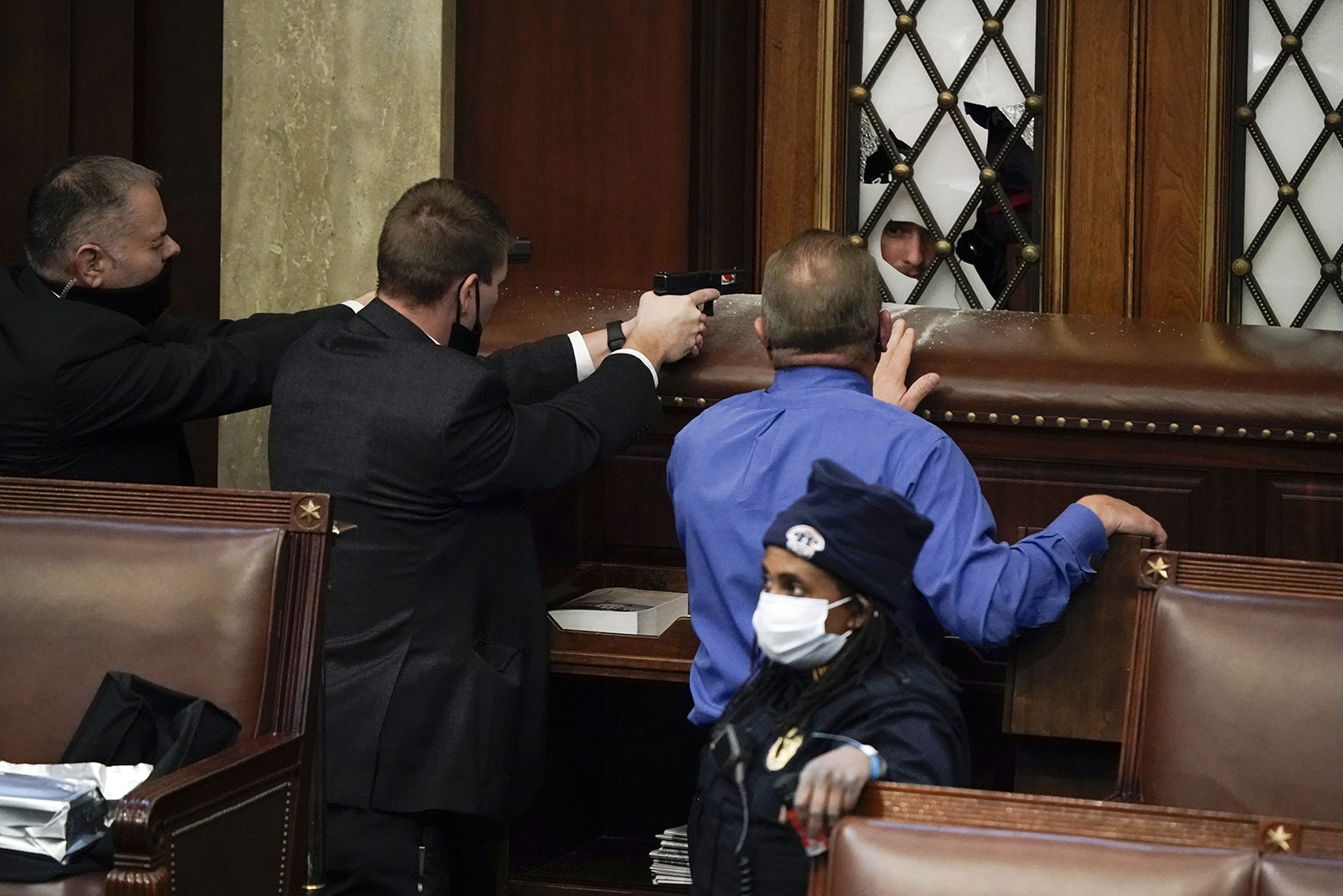FILE - In this Jan. 6, 2021, file photo U.S. Capitol Police officers with guns drawn and Rep. Troy Nehls, R-Texas, in blue shirt, watch as insurrections loyal to President Donald Trump try to break into the House Chamber at the U.S. Capitol in Washington. (AP Photo/J. Scott Applewhite, File)