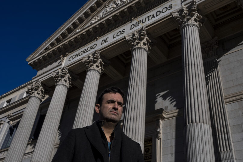 Miguel Hurtado, who has campaigned against impunity since disclosing his own account of being abused at a monastery in northeastern Spain, poses for a picture in front of a Spanish parliament in Madrid, Spain, Tuesday, Feb. 1, 2022. (AP Photo/Manu Fernandez)