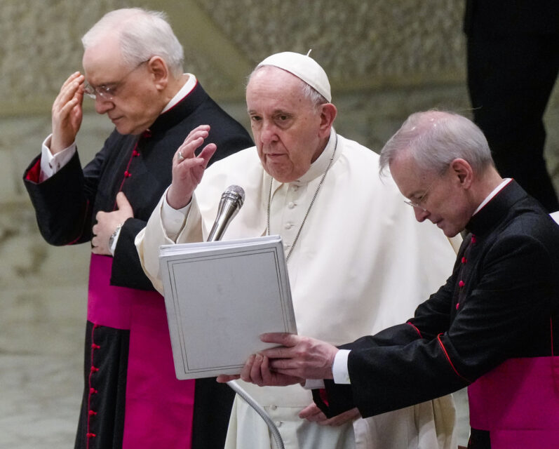 Pope Francis, center, flanked by Monsignor Leonardo Sapienza, left, blesses the attendance at the end of his weekly general audience in the Paul VI Hall at the Vatican, Wednesday, Feb. 02, 2022. (AP Photo/Gregorio Borgia)