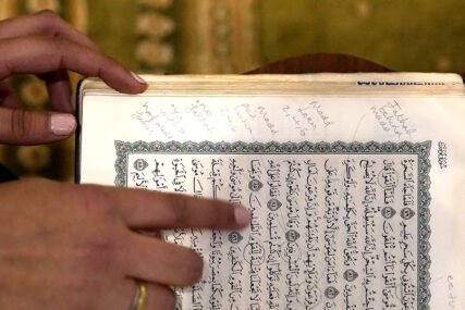 Madinah Javed points out marginal notes she wrote in her childhood Quran while learning to be a reciter, in a prayer room at the American Islamic College Thursday, Jan. 27, 2022, in Chicago. (AP Photo/Charles Rex Arbogast)