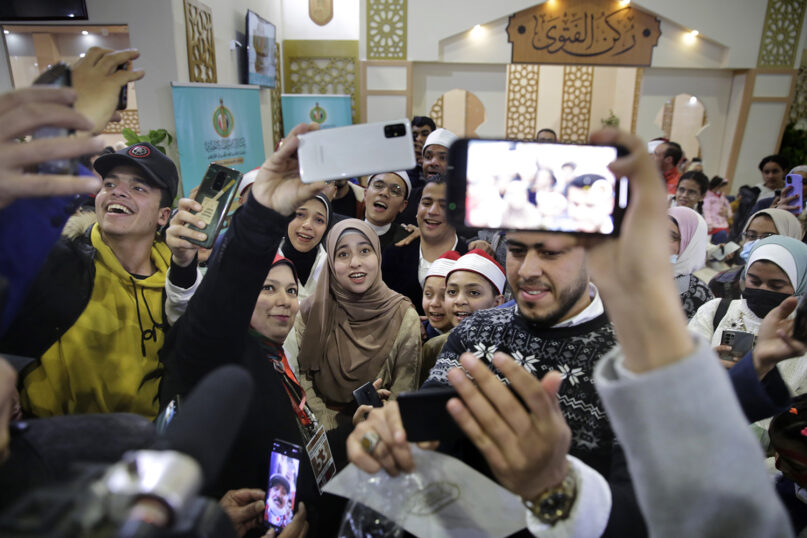 Al-Zahraa Layek Helmee, center, is surrounded by her fans for selfie pictures at the annual Cairo International Book Fair, in Cairo, Egypt, Feb. 4, 2022. Online, where Helmee has 1.2 million followers on Facebook, many cheer her on. Others -- men and women -- reprimand her in messages, urging her to “fear God” or arguing that her voice can tempt men, an idea she rejects. (AP Photo/Amr Nabil)