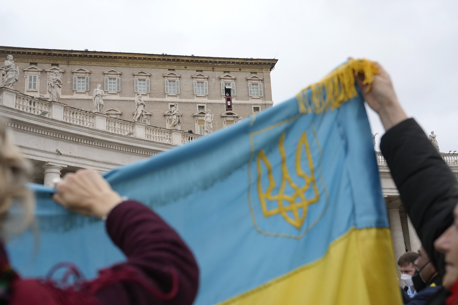 Ukrainian faithful hold their national flag as Pope Francis delivers the Angelus noon prayer from his studio window overlooking St. Peter’s Square, at the Vatican, Feb. 20, 2022. (AP Photo/Gregorio Borgia)