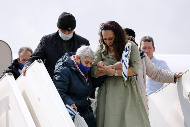 Yael Eckstein, right, helps Koronina Nelia deboard a plane at Ben Gurion Airport in Tel Aviv, Israel, Sunday, Feb. 20, 2022. Photo courtesy of Ilan Assayag