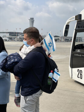 Evgeni carries his daughter as Jewish immigrants from Ukraine arrive at Ben Gurion Airport in Tel Aviv, Israel, Sunday, Feb. 20, 2022. Photo courtesy of Johnnie Moore