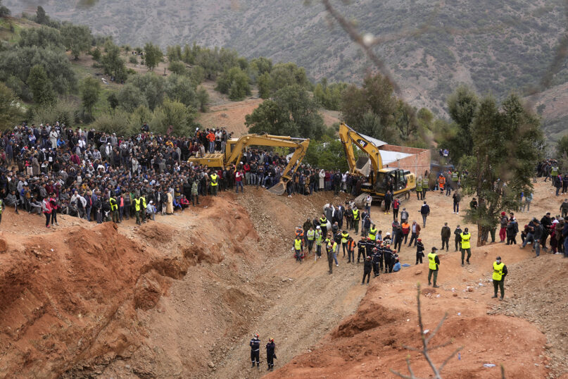 A crowd of locals watches as civil defense workers and local authorities attempt to rescue Rayan, a 5-year-old boy who fell into a well in northern Morocco, Feb. 4, 2022. (AP Photo/Mosa'ab Elshamy)