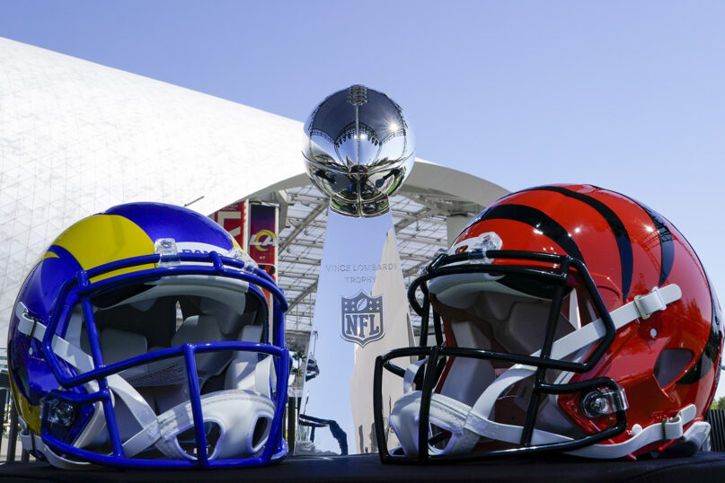 The Vince Lombardi Trophy is seen at a news conference between helmets of the Los Angeles Rams, left, and Cincinnati Bengals, Wednesday, Feb. 9, 2022, in Inglewood, California. (AP Photo/Morry Gash)