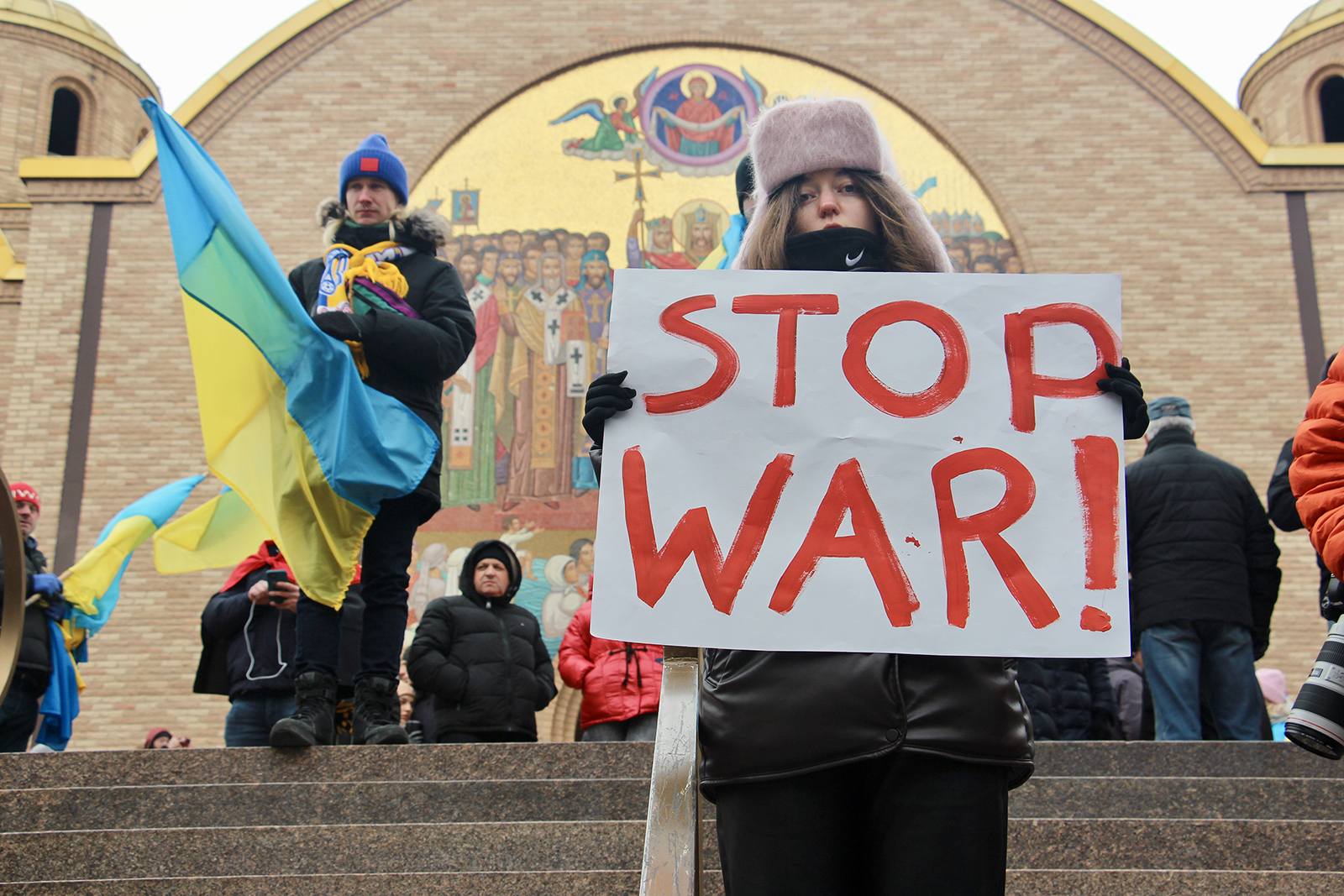 Inna Zotikova, 26, of Chicago, holds a sign during a rally outside the Sts. Volodymyr and Olha Ukrainian Catholic Church in Chicago's Ukrainian Village neighborhood, Thursday, Feb. 24, 2022. RNS photo by Emily McFarlan Miller