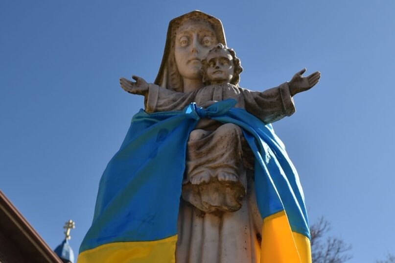 The flag of Ukraine has been tied around a statue of the Virgin Mary and Jesus Christ outside a church in Pennsylvania amid the Russian invasion. ()
