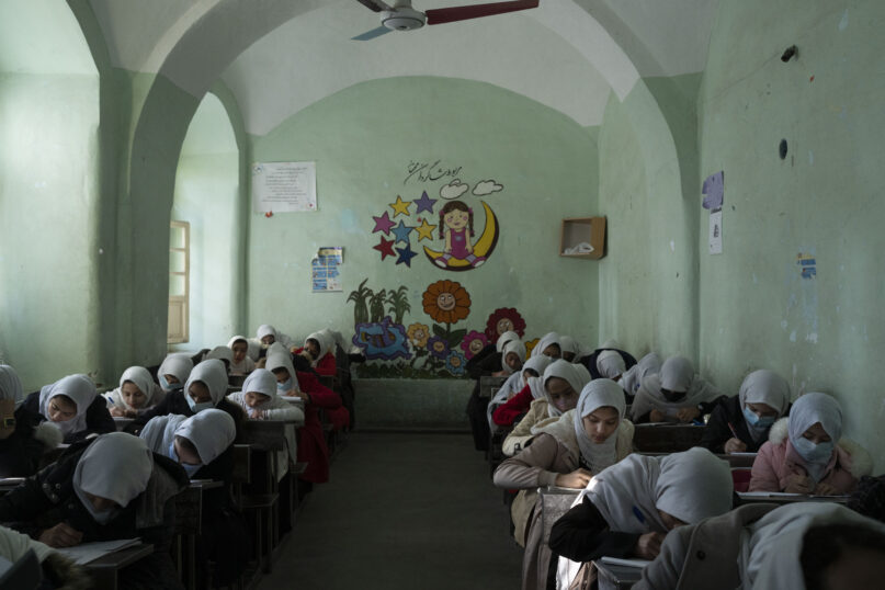 FILE - Afghan girls participate a lesson inside a classroom at Tajrobawai Girls High School, in Herat, Afghanistan, Nov. 25, 2021. Taliban hard-liners are turning back the clock in Afghanistan with a flurry of repressive edicts over the past days that hark back to their harsh rule from the late 1990s. Girls have been banned from going to school beyond the sixth grade, women are turned back from boarding planes if they travel unaccompanied by a male relative. (AP Photo/Petros Giannakouris, File)