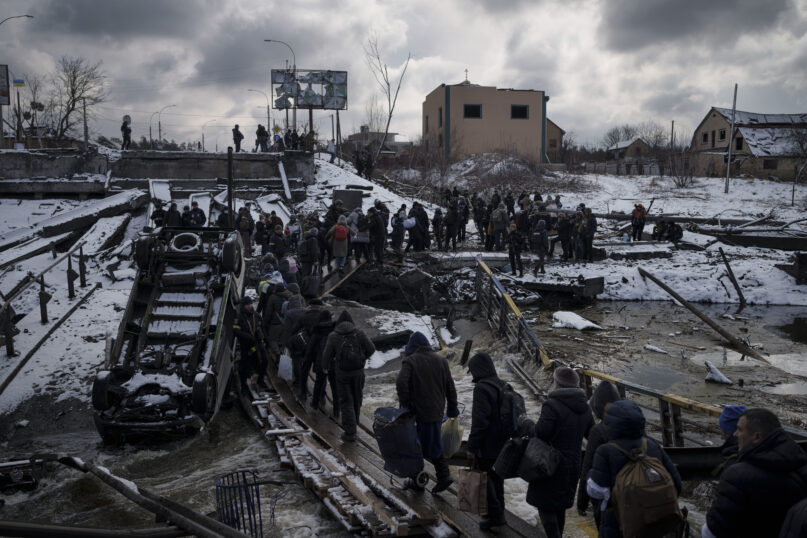 Ukrainians cross an improvised path under a destroyed bridge while fleeing Irpin, in the outskirts of Kyiv, Ukraine, March 8, 2022. (AP Photo/Felipe Dana)