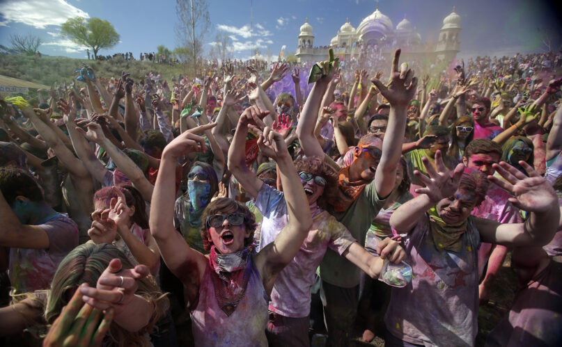 Revelers covered in colored cornstarch celebrate during the 2015 Festival of Colors Holi Celebration at the Krishna Temple in Spanish Fork, Utah, March 28, 2015. (AP Photo/Rick Bowmer)