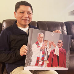 Jose Ortiz, de 53 a–os, sostiene una imagen de Rutilio Grande y san Oscar Romero en su casa en Los çngeles mientras se sienta para un retrato el 8 de marzo. Foto de RNS por Alejandra Molina