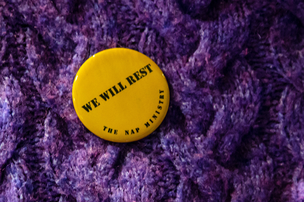 An individual wears a "We Will Rest" pin from The Nap Ministry. Photo by Stanchez Kenyata