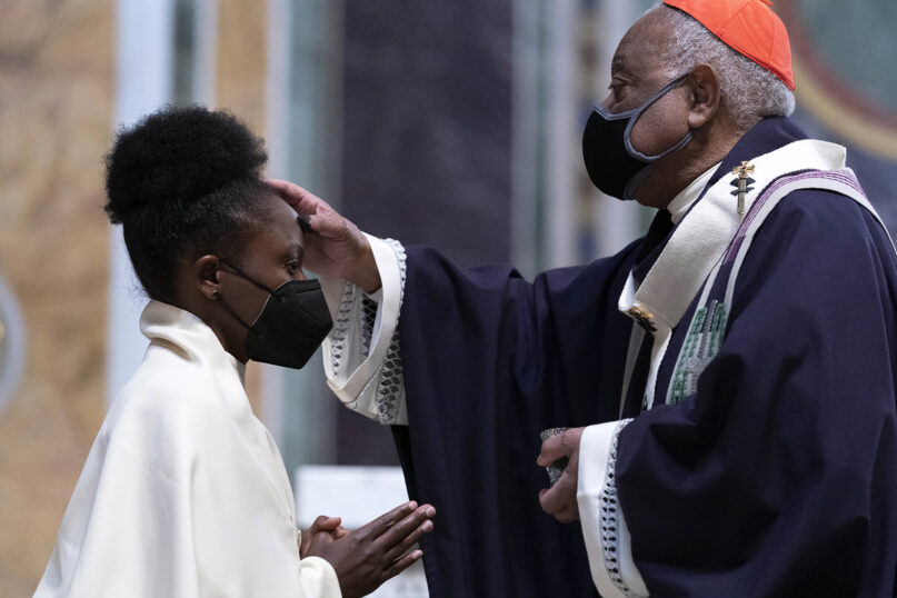 Cardinal Wilton Gregory, Archbishop of Washington, places ashes on the forehead of a parishioner during the Ash Wednesday Mass at Saint Matthew the Apostle Cathedral in Washington, Wednesday, March, 2, 2022. (AP Photo/Jose Luis Magana)