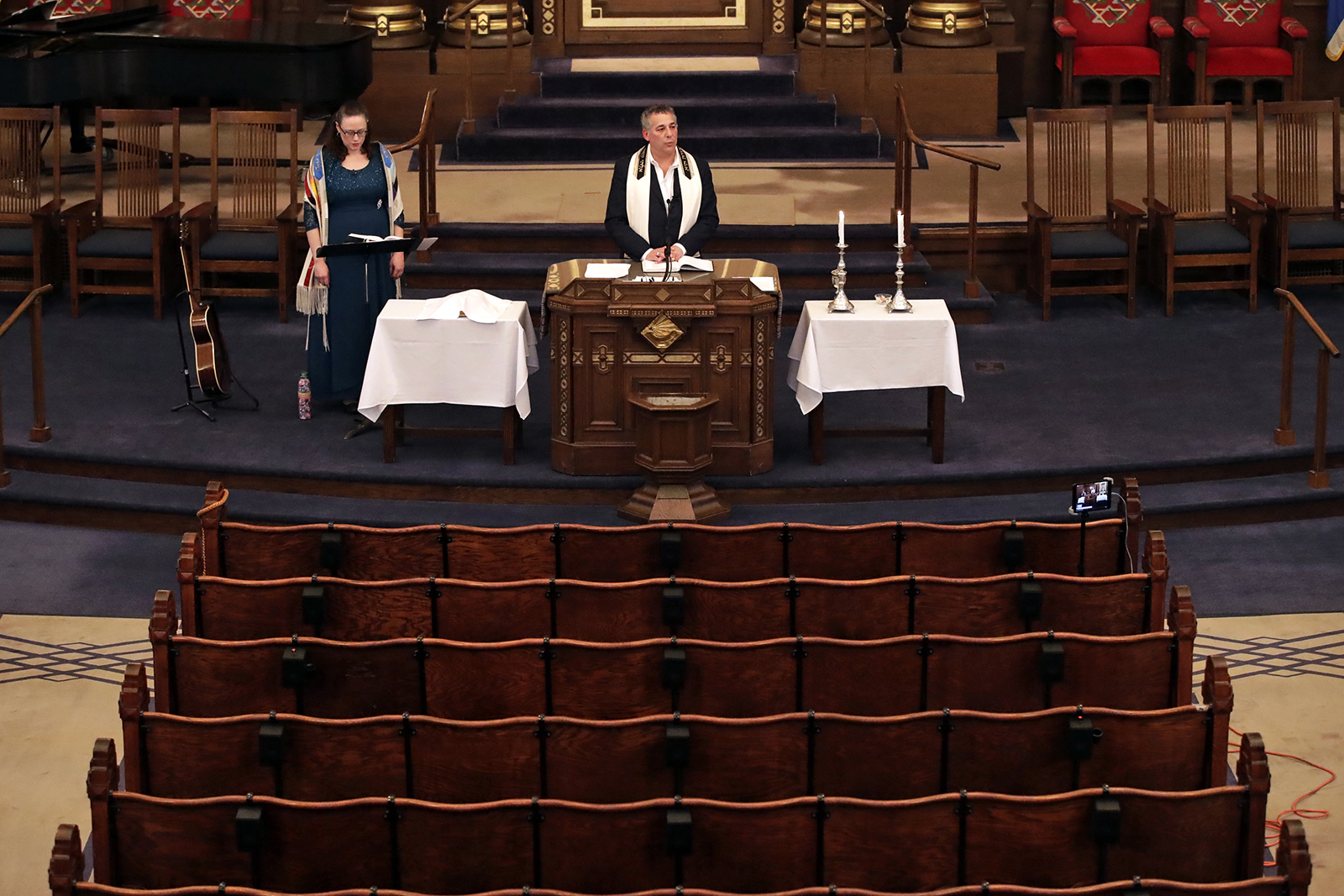 Rodef Shalom Rabbi Aaron Bisno, center, delivers his sermon with soloist Molly May, left, during a service that was streamed live, Friday, March 20, 2020. (AP Photo/Gene J. Puskar)