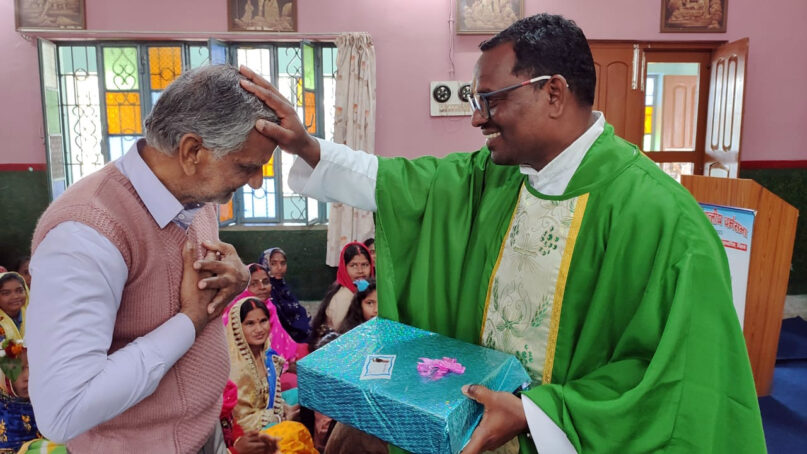 The Rev. Vikas Nayak blesses a devotee during a prayer service at Jagdishpur Church in Buxar, India, on Feb. 13, 2022. Photo by Abhijeet Nayak