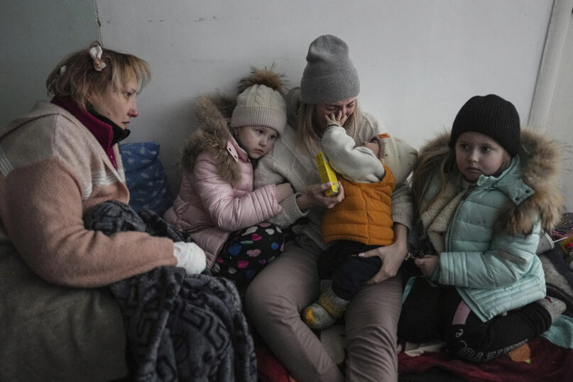 Women and children shelter on the floor of a corridor in a hospital in Mariupol, eastern Ukraine, March 11, 2022. Mariupol has been under siege for over a week, with no electricity, gas or water. Repeated efforts to evacuate people from the city of 430,000 have fallen apart as humanitarian convoys come under shelling. (AP Photo/Evgeniy Maloletka)