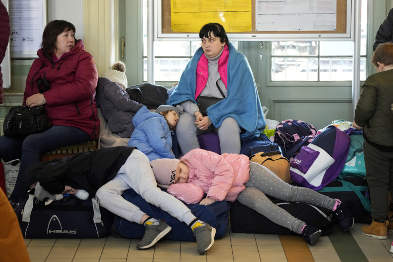 Children from Ukraine sleep at a railway station in Przemysl, southeastern Poland, on March 23, 2022. (AP Photo/Sergei Grits)