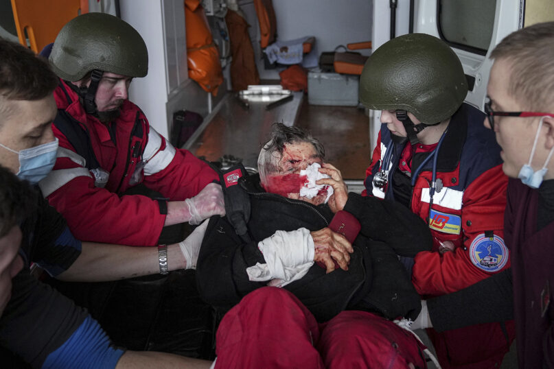 Ambulance paramedics move a Ukrainian civilian wounded by Russian shelling onto a stretcher in a maternity hospital converted into a medical ward in Mariupol, Ukraine, Wednesday, March 2, 2022. Russian forces have seized a strategic Ukrainian seaport and besieged another. Those moves are part of efforts to cut the country off from its coastline even as Moscow said Thursday it was ready for talks to end the fighting. (AP Photo/Evgeniy Maloletka)
