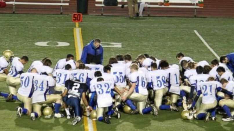 Football coach Joe Kennedy leading players in prayer in 2015. Video screen grab