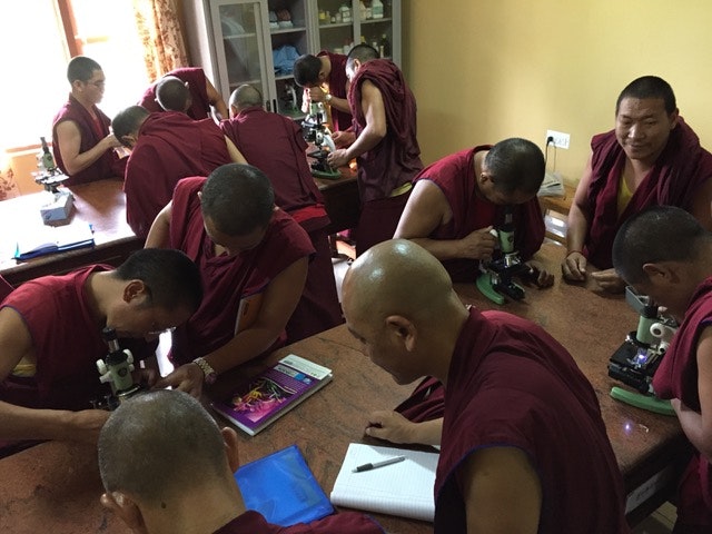 Tibetan monks at Sera Jey Monastery in Mysore, India, experience using microscopes for the first time. (Courtesy of Dan Pierce</span>, <a class=