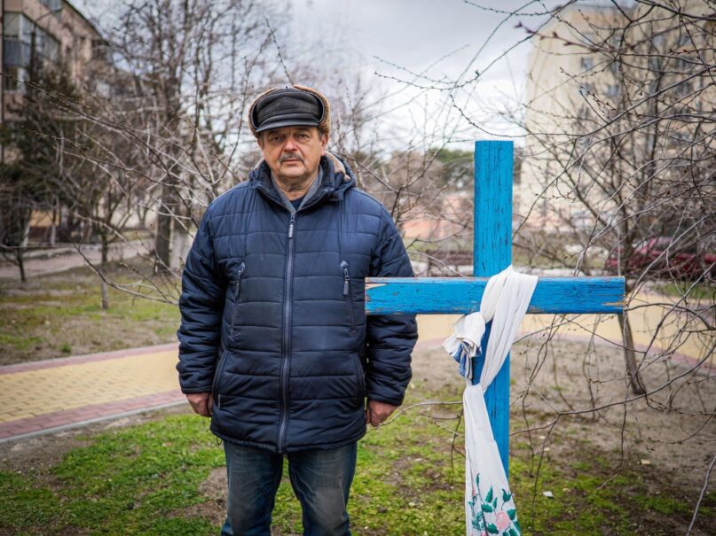 A man identified only as Viktor shows his neighbor's grave in Bucha, Ukraine. It was too dangerous to go to the cemetery. (Jana Cavojska/SOPA Images/LightRocket via Getty Images)