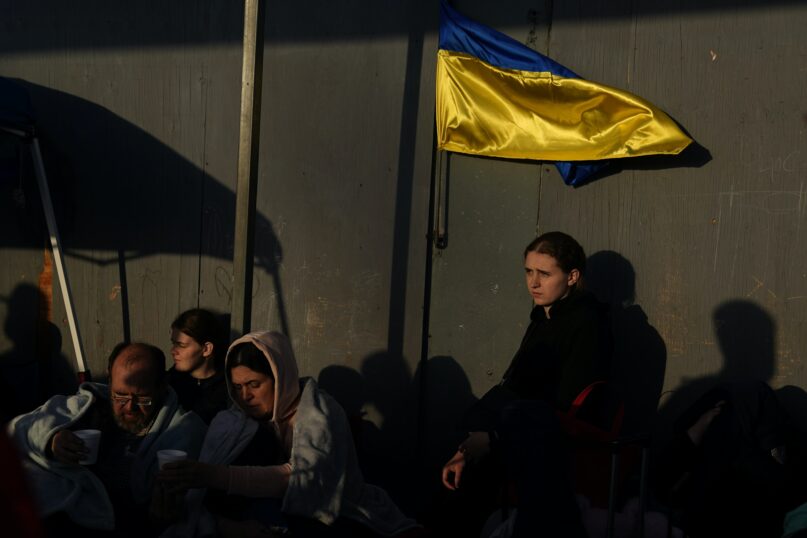 Ukrainian refugees wait near the U.S. border in Tijuana, Mexico. (AP Photo/Gregory Bull)