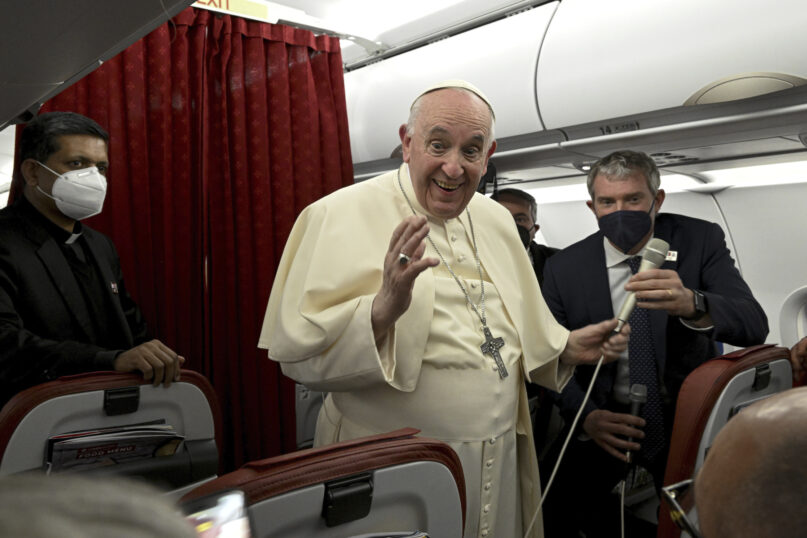 Pope Francis greets journalists aboard the papal plane during the flight back to Rome at the end of his two-day apostolic visit to Malta, Sunday, April 3, 2022. (Ciro Fusco /Pool photo via AP)